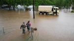 Texas Guardsmen and Texas Task Force 1 rescue personnel wade through thigh-deep water to  help stranded residents back to rescue vehicles during severe flooding in Wharton, Texas, April 21, 2016. In coordination with Texas Task Force 1 and the City of Wharton emergency services, a detachment from Delta Company of the 536th Brigade Support Battalion, Texas Army National Guard deployed several Light Multi-terrain Vehicles to floodwaters rescuing both people and pets. 