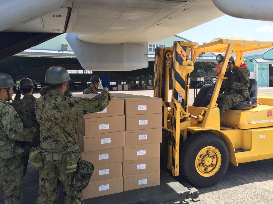 Japanese soldiers prepare to guide a forklift carrying humanitarian aid for loading into a U.S. Marine Corps MV-22B Osprey aircraft at Kumamoto airport on Kyushu Island, Japan, April 22, 2016. The aircraft is assigned to Marine Medium Tiltrotor Squadron 265, 31st Marine Expeditionary Unit. The humanitarian aid is supporting relief efforts after a series of earthquakes struck the island. Marine Corps photo by Capt. Jennifer Giles