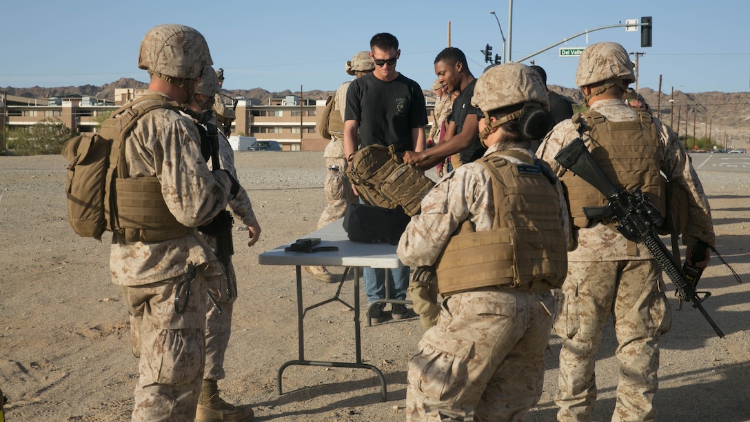 Marines with Combat Logistics Battalion 24 begin to check role-players through their Evacuation Control Center set at Del Valle Field Marine Corps Air Ground Combat Center Twentynine Palms, California, as part of a Non-combatant Evacuation Operation exercise in support of Weapons and Tactics Instructor Course 2-16 April 15, 2016. 