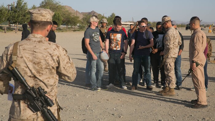 Marine role-players begin their screening to board an aircraft for extraction at Del Valle Field Marine Corps Air Ground Combat Center Twentynine Palms, California, as part of a Non-combatant Evacuation Operation exercise in support of Weapons and Tactics Instructor Course 2-16 April 15, 2016. 