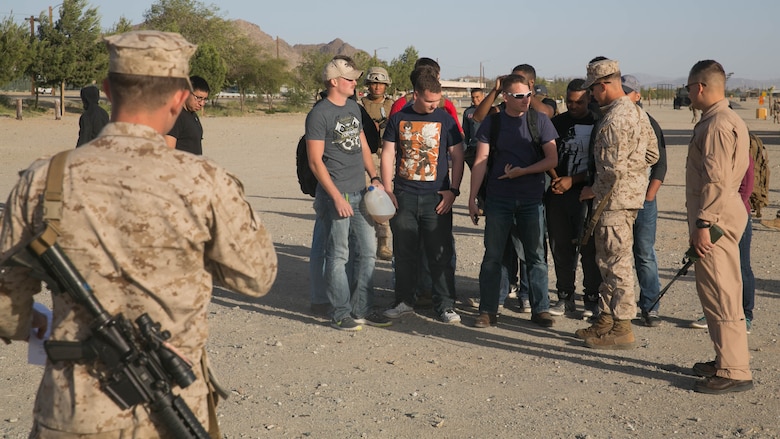 Marine role-players begin their screening to board an aircraft for extraction at Del Valle Field Marine Corps Air Ground Combat Center Twentynine Palms, California, as part of a Non-combatant Evacuation Operation exercise in support of Weapons and Tactics Instructor Course 2-16 April 15, 2016. 