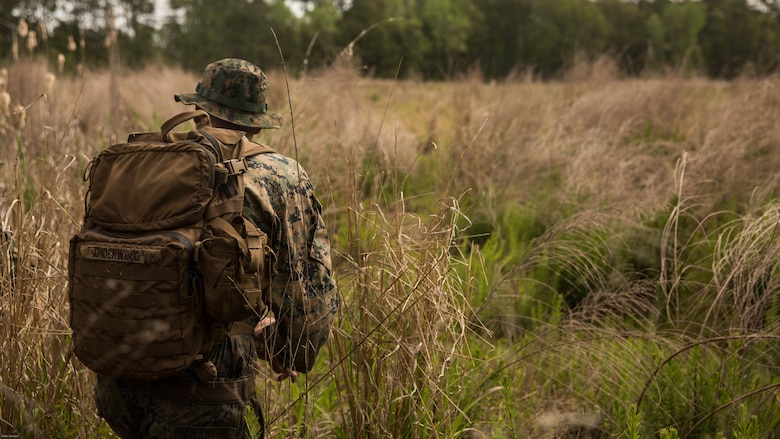 Lance Cpl. Jacob Underwood, a rifleman with 2nd Battalion, 8th Marine Regiment, seeks concealment behind vegetation during an assault on an objective during an attack evolution at Marine Corps Base Camp Lejeune, N.C., April 20, 2016. Role players were placed throughout the course, adding various scenarios which included ambushing a patrol and assaulting an enemy fortified position.