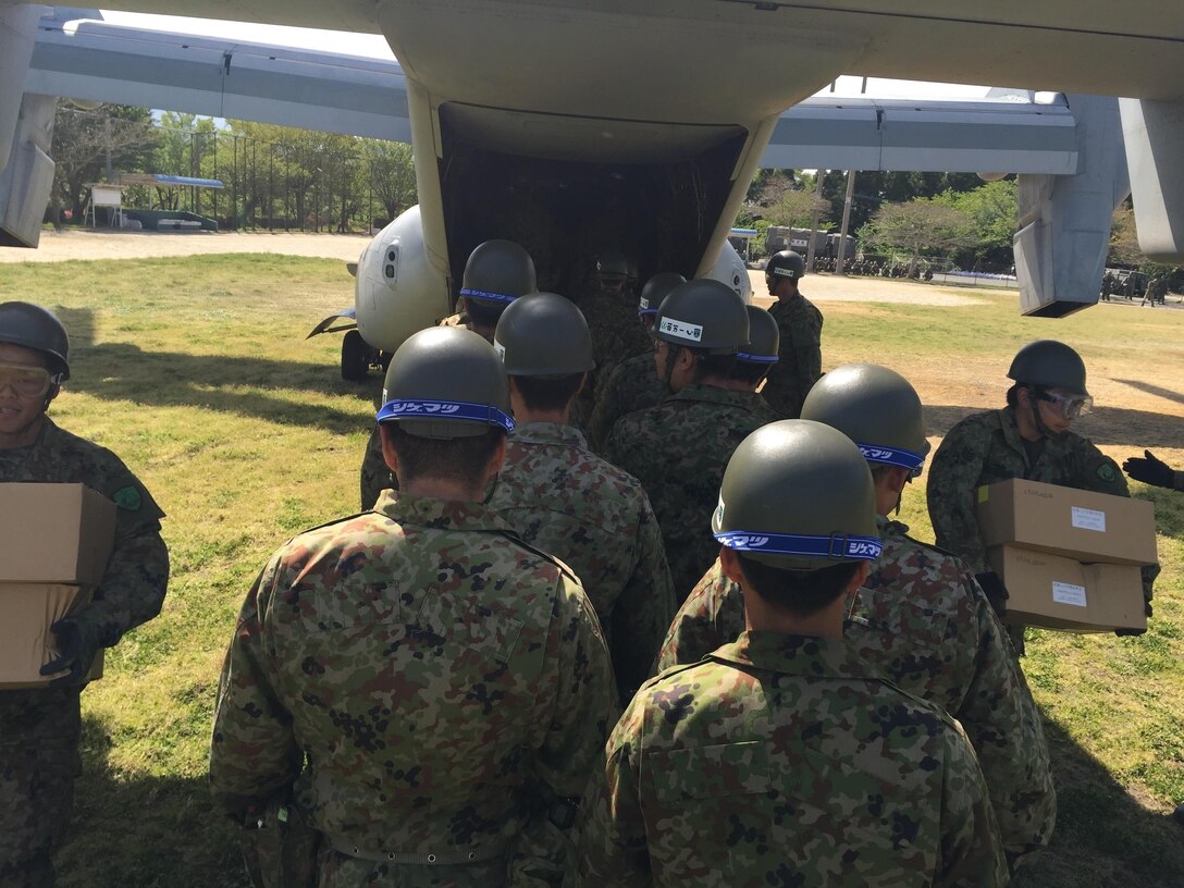 Japanese soldiers unload relief supplies from a U.S. Marine Corps MV-22B Osprey aircraft at the Hakusui Sports Park on Kyushu Island, Japan, April 22, 2016. Marine Corps photo by Capt. Jennifer Giles