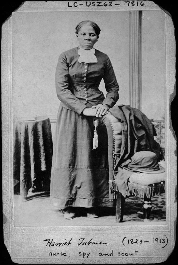 Harriet Tubman, full-length portrait, standing with hands on back of a chair. Between ca. 1860 and 1875.