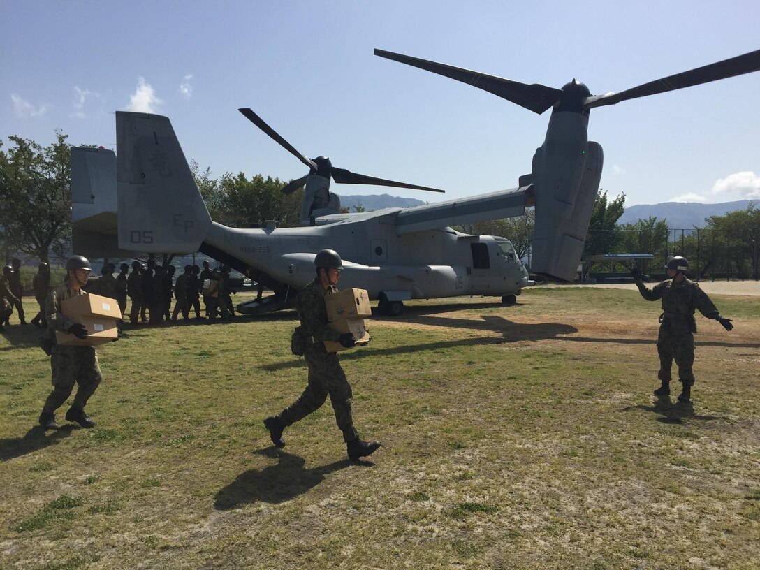 Japanese soldiers carry boxes of relief supplies from a U.S. Marine Corps MV-22B Osprey aircraft at the Hakusui Sports Park on Kyushu Island, Japan, April 22, 2016. Marine Corps photo by Capt. Jennifer Giles