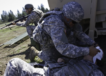 Pvt. 1st Class Elmer Escalante, a supply specialist with the 145th Multifunctional Medical Brigade, an Army Reserve unit from Garden Grove, California, bandages a simulated head wound on Spc. Fangze Cui, a dental assistant with the 673rd Dental Company, 62nd Medical Brigade, 593rd Expeditionary Sustainment Command, during a total force integrated training exercise at Joint Base Lewis-McChord, Washington, April 18-29, 2016. Army Soldiers and reservists shared tactical and professional experiences during the joint exercise. (U.S. Army photo by Sgt. Cody Quinn/28th Public Affairs Detachment)