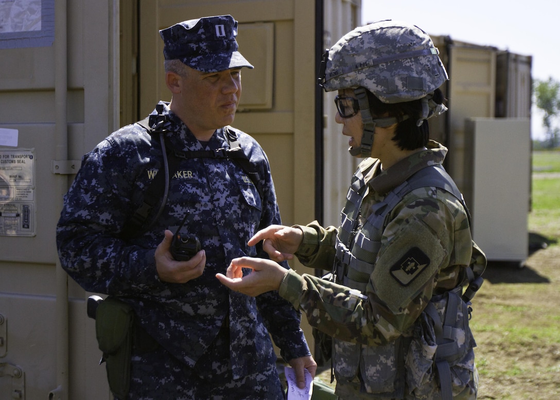 Navy Capt. Beecher Whiteaker, a dentist with Naval Hospital Oak Harbor, Washington, recieves guidance from Col. Christensen Hsu, commander of the 673rd Dental Company, 62nd Medical Brigade, 593rd Expeditionary Sustainment Command, during a total force integrated training exercise at Joint Base Lewis-McChord, Washington, April 18-29, 2016. Dental professionals with the Army, Army Reserves and Navy came together to perform dental care in a deployed environment during the exercise. (U.S. Army photo by Sgt. Cody Quinn/28th Public Affairs Detachment)