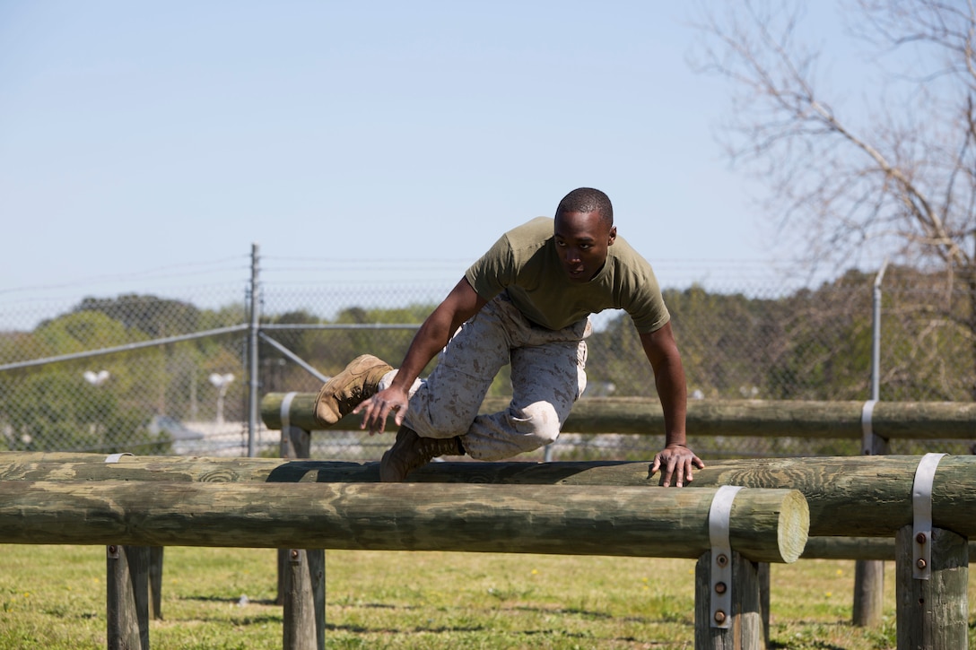U.S. Marine Sgt. Aeryk Brandon Church, a surface/system embarkation chief at U.S. Marine Corps Forces Command, jumps over a series of logs during the obstacle course relay as part of the Titan Challenge April 14 aboard Camp Allen,                                                          Norfolk, Va. The Titan Challenge was a four-part event which included; an O-course relay, pull-up/ push-up ladder, tire flips, and a casualty evacuation race in which teams of four competed for first place. The Titan Challenge was an opportunity for Marines and Sailors to practice unit cohesion and camaraderie outside of the normal work routine. (Photo by U.S. Marine Cpl. Jessika Braden/ Released)