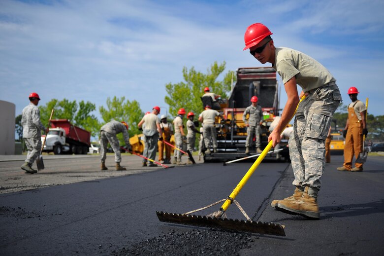 Airman 1st Class Bryan Daniel, a heavy equipment operator with the 823rd RED HORSE squadron, sifts freshly-laid asphalt to the proper depth at Hurlburt Field, Fla., April 20, 2016. As part of a two-week milling and paving training course, more than 20 Airmen from across the globe participated by laying asphalt to repair a parking lot. (U.S. Air Force photo by Airman 1st Class Joseph Pick)