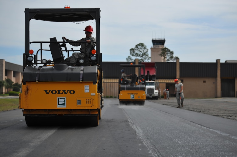 Airman 1st Class Jessie Ledesma, a heavy equipment operator with the 823rd RED HORSE squadron, operates a steel-wheel roller over freshly laid asphalt on Hurlburt Field, Fla., April 20, 2016. As part of a two-week milling and paving training course, Airmen from across the globe laid more than 250 tons of asphalt to repair a parking lot. (U.S. Air Force photo by Airman 1st Class Joseph Pick)
