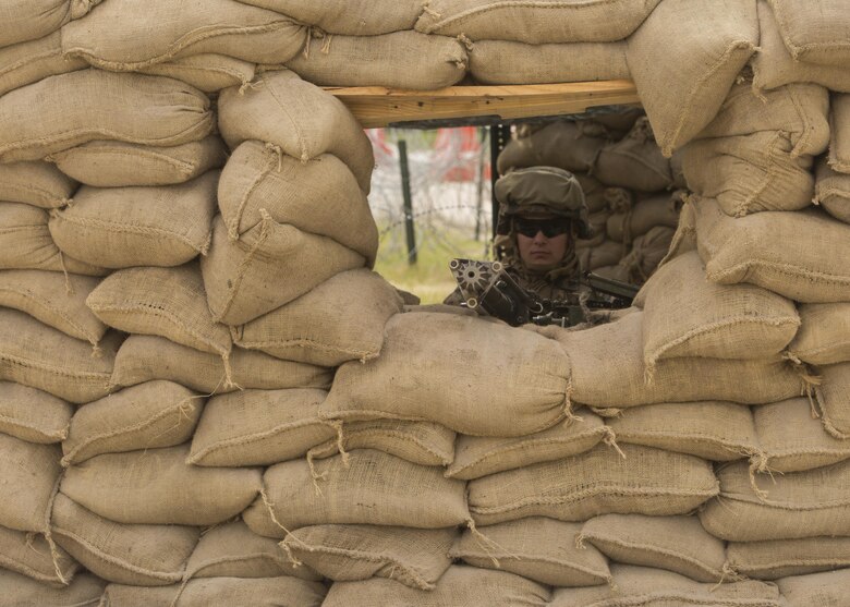 Cpl. Jacob Lebo, a rifleman with 1st Platoon, Bravo Company, 2nd Law Enforcement Battalion, mans the main security post built using over 600 sandbags with his .50 caliber machine gun during the II Marine Expeditionary Force Command Post Exercise 3 at Camp Lejeune, N.C., April 20, 2016. During the CPX, 2nd LEB posted security around the campsite and defend it from mock enemies, ensuring the headquarters element could complete the mission safely. (U.S. Marine Corps photo by Cpl. Michelle Reif/Released)