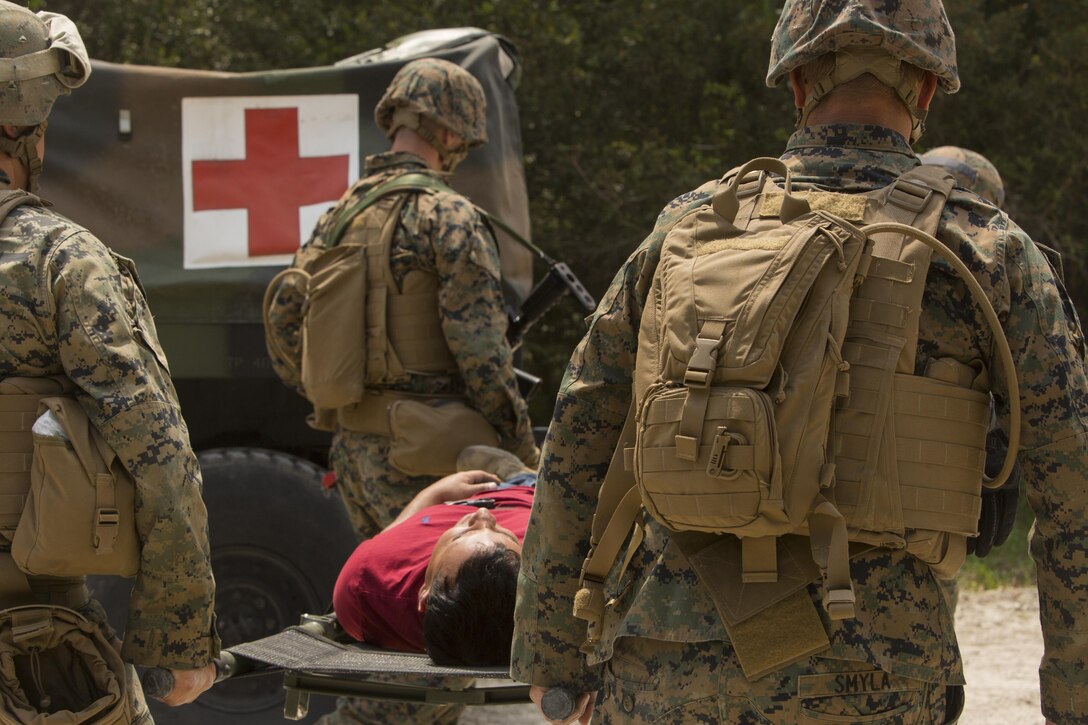 Marines with 2nd Law Enforcement Battalion and Navy Corpsmen carry a simulated enemy combatant to the medical vehicle after he was captured during a perimeter security patrol during the II Marine Expeditionary Force Command Post Exercise 3 at Camp Lejeune, N.C., April 20, 2016. During the CPX, 2nd LEB posted security around the campsite and defended it from mock enemies, ensuring the headquarters element could complete the mission safely. (U.S. Marine Corps photo by Cpl. Michelle Reif/Released)