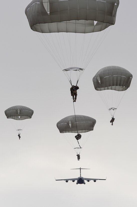 Paratroopers descend after jumping from an Air Force C-17 Globemaster III during a practice forced-entry parachute assault on Malemute drop zone at Joint Base Elmendorf-Richardson, Alaska, April 5, 2016. Air Force photo by Alejandro Pena