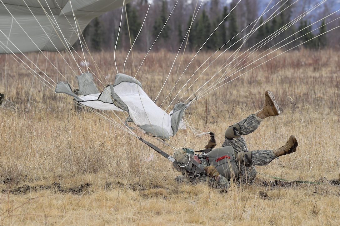 A paratrooper lands during a practice forced-entry parachute assault on Malemute drop zone at Joint Base Elmendorf-Richardson, Alaska, April 5, 2016. Air Force photo by Alejandro Pena