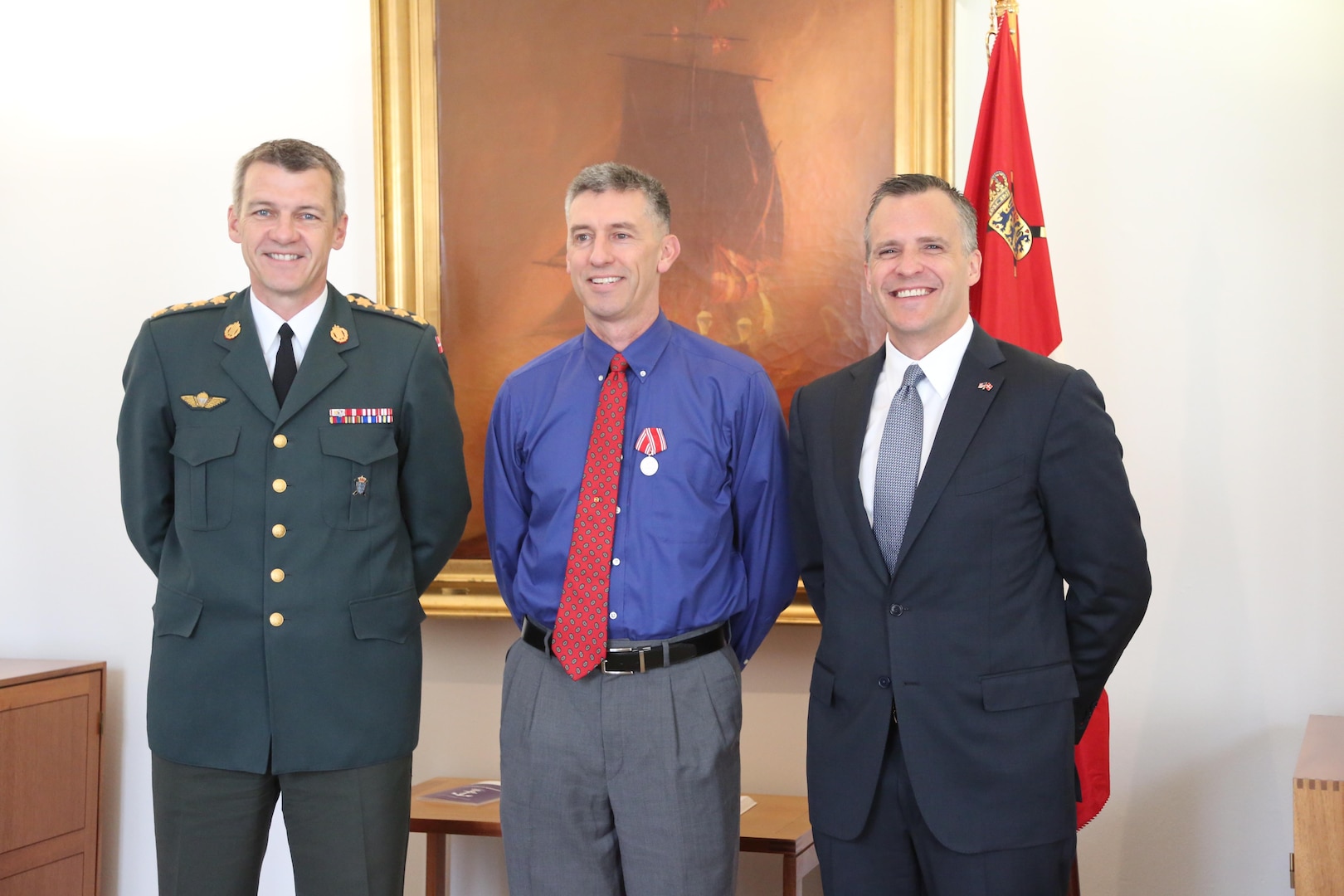 Capt. Bradley Grimm, center,Texas Army National Guard, receives the Danish Defense Medal for Special Meritorious Efforts by Danish Defense Gen. Peter Bartram, left, and American ambassador to Denmark Rufus Gifford, right, at a ceremony held in Denmark, April 19, 2016.  Grimm was instrumental in foiling a terrorist plot to bomb a Danish school and assisted Danish security forces in making an arrest. (Danish Military photo by Sune Wadskjær/Released)