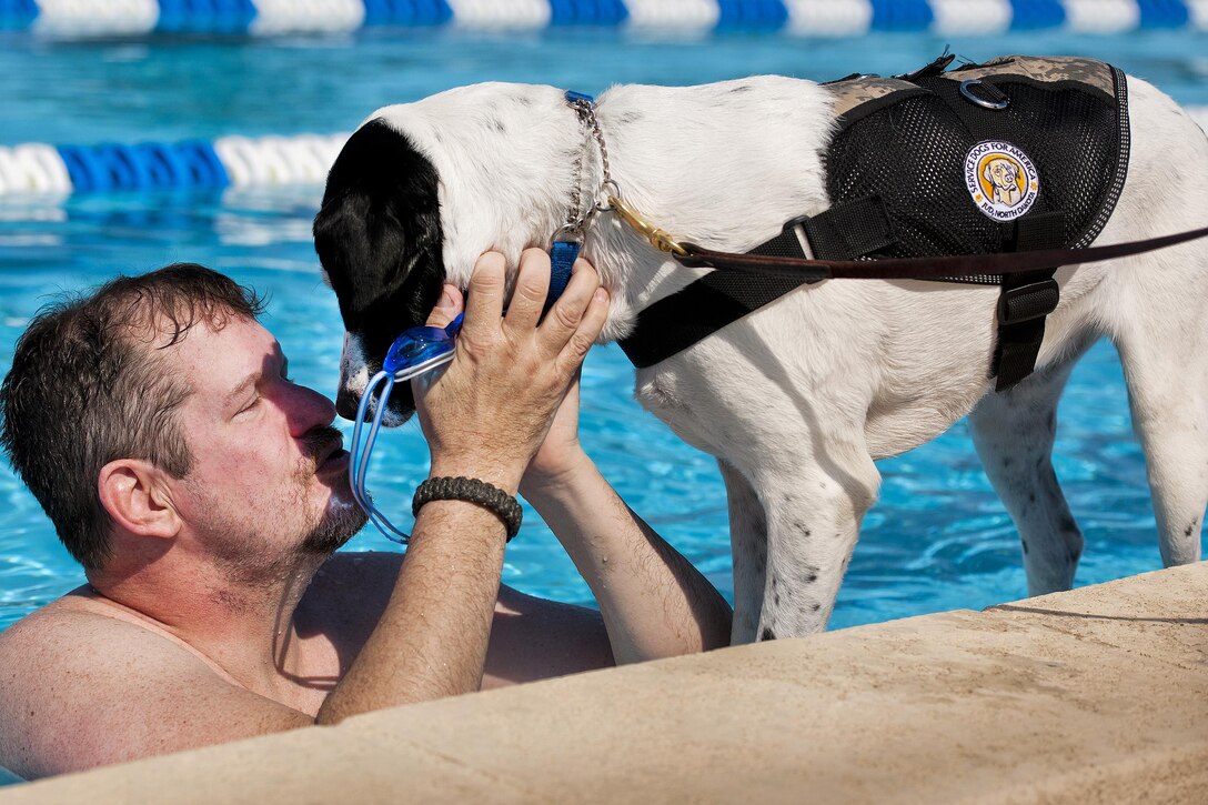 Eric Fisher, a Warrior Games athlete, plays with Lola, his military working dog, after a morning swim session as part of an adaptive sports camp at Eglin Air Force Base, Fla., April 7, 2016. This was the first time Williamson returned to the pool after a leg amputation. Air Force photo by Samuel King Jr.