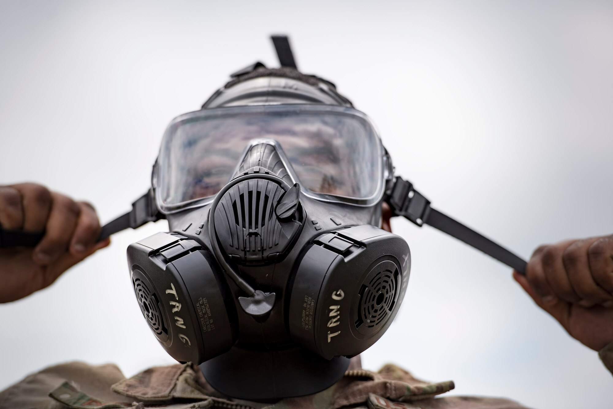 U.S. Air Force Senior Airman Eric Purnell, 823d Base Defense Squadron fireteam member, tightens a gas mask, April 13, 2016, Avon Park Air Force Range, Fla. Part of the obstacle course challenge involved dressing in full mission-oriented-protective-posture gear and being cleared by cadre before moving on to the next obstacle. (U.S. Air Force photo by Airman 1st Class Janiqua P. Robinson/Released)