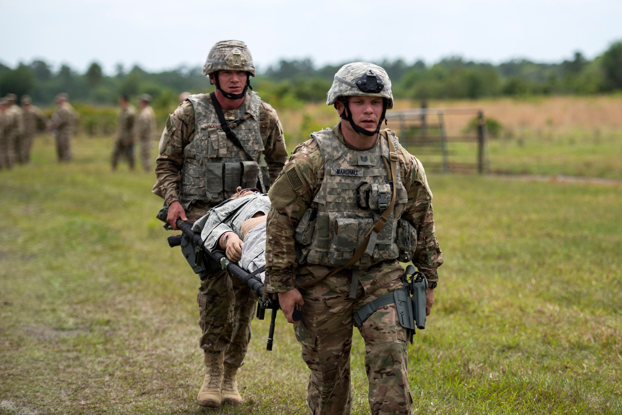 U.S. Air Force Tech Sgt. Brian Marshall, 823d Base Defense Squadron NCO in charge of training, and Staff Sgt. James Jackson, 823d BDS support NCO in charge, carry a dummy that weighed nearly 200 pounds, April 13, 2016, at Avon Park Air Force Range, Fla. This task was part of an obstacle course that also included disassembly and reassembly of a rifle and dressing in full mission oriented protective posture gear. (U.S. Air Force photo by Airman 1st Class Janiqua P. Robinson/Released)