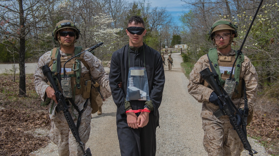 Students at the new Marine Military Police Officer Basic Course escort a captured enemy during a field exercise at Fort Leonard Wood, Missouri, April 14, 2016. The exercise is made to simulate situations MPs might come across in the fleet. 