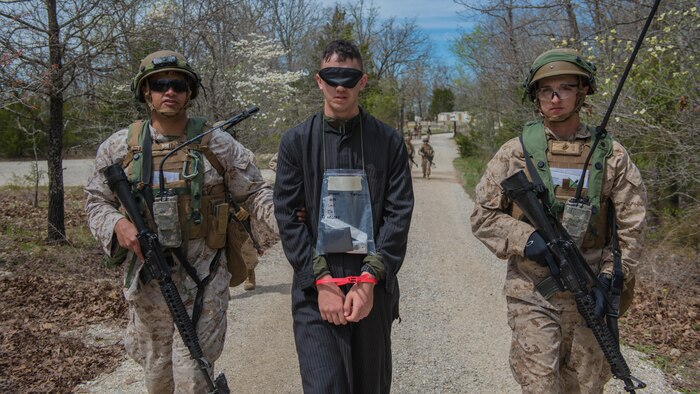 Students at the new Marine Military Police Officer Basic Course escort a captured enemy during a field exercise at Fort Leonard Wood, Missouri, April 14, 2016. The exercise is made to simulate situations MPs might come across in the fleet. 