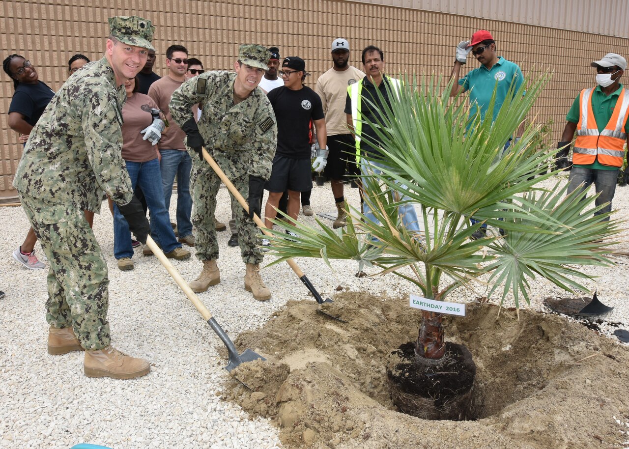 Navy Capt. Cory Howes, commander of Naval Support Activity Bahrain, center, and Cmdr. Steven Williams, executive officer of NSA Bahrain, left, plant a tree in observation of Earth Day at Naval Support Activity Bahrain, Manama, Bahrain, April 20, 2016. Navy photo by Petty Officer 2nd Class John Benson