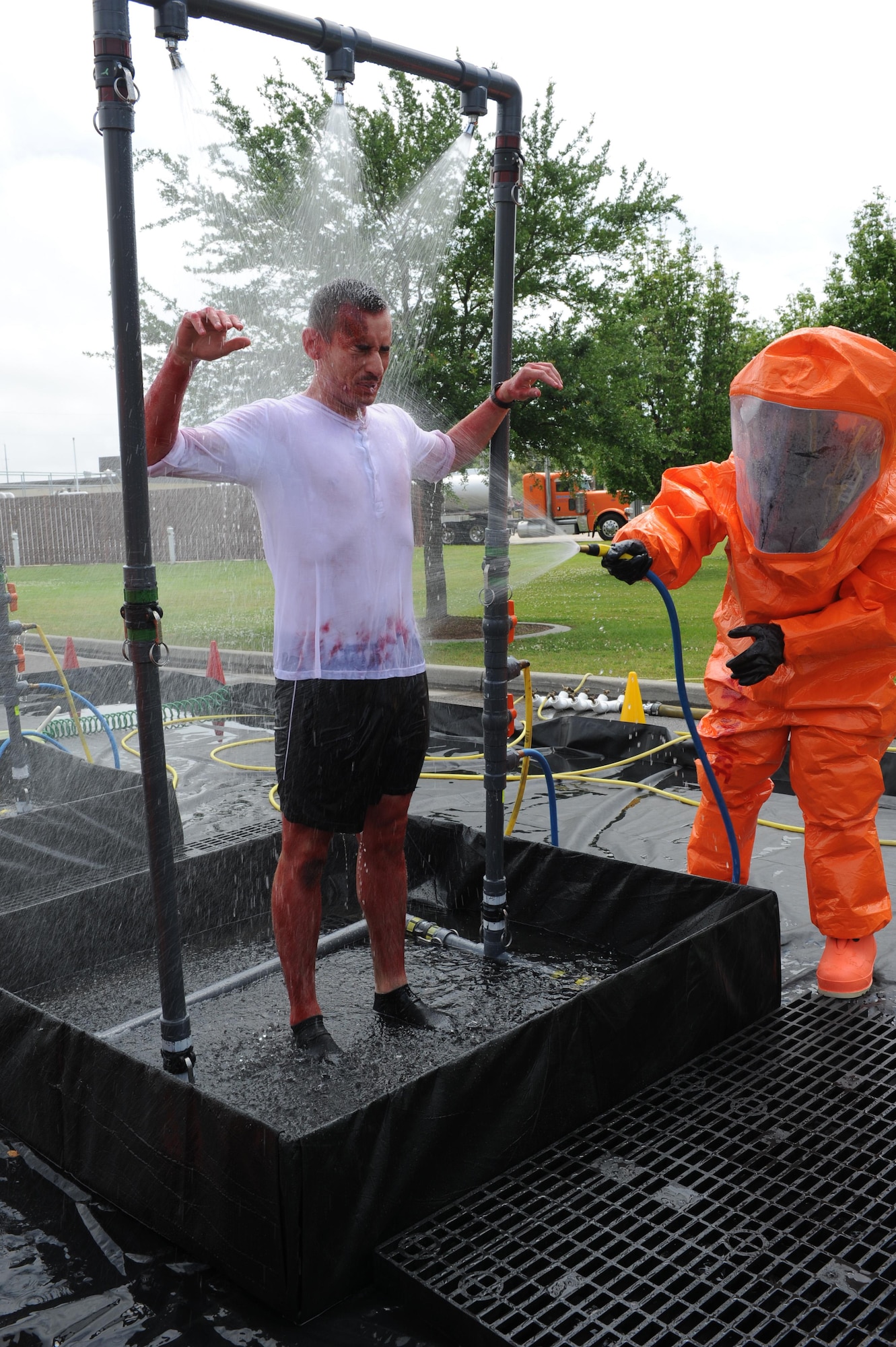 An 81st Infrastructure Division firefighter follows decontamination procedures on Airman 1st Class David Brown, 336th Training Squadron student, as he portrays a “victim” who was contaminated during a Chemical, Biological, Radiological, Nuclear and Explosive exercise scenario, April 21, 2016, Keesler Air Force Base, Miss. The Force Protection Condition exercise scenario simulated an intruder entering the hazardous waste 90-day accumulation site, where an explosion occurred causing a mass casualty event. The exercise tested the base’s capability to react to and recover from a mass casualty event. (U.S. Air Force photo by Kemberly Groue)