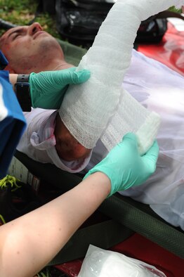 Airman 1st Class David Brown, 336th Training Squadron student, portrays a “victim” receiving medical triage during a Chemical, Biological, Radiological, Nuclear and Explosive exercise scenario, April 21, 2016, Keesler Air Force Base, Miss. The Force Protection Condition exercise scenario simulated an intruder entering the hazardous waste 90-day accumulation site, where an explosion occurred causing a mass casualty event. The exercise tested the base’s capability to react to and recover from a mass casualty event. (U.S. Air Force photo by Kemberly Groue)