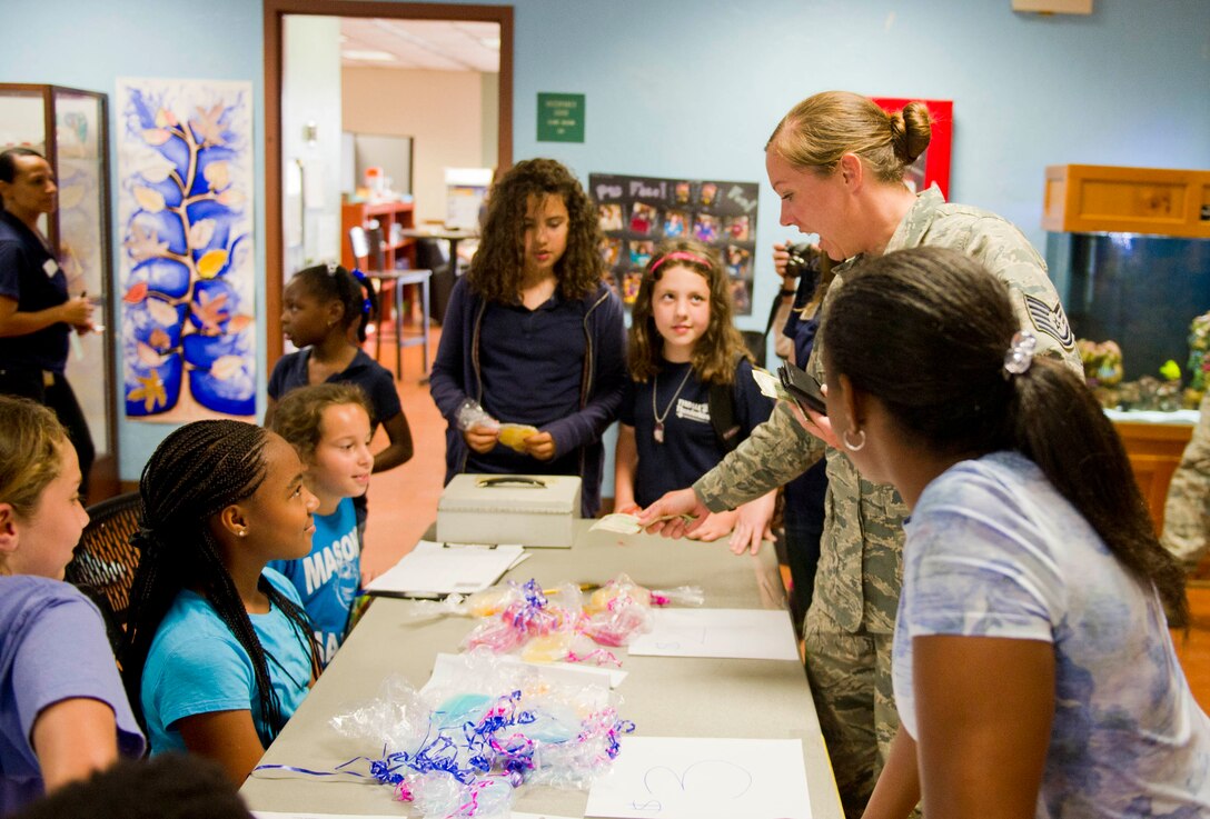 Technical Sgt. Jennifer Hall, 325th Maintenance Group quality assurance inspector, purchases handmade soap from kids April 20 at the Youth Center. The money raised from selling soap will fund an educational field trip. The Youth Center, or Youth Programs, offers children on Tyndall different activities such as youth sports and before and after school programs and provides the children on Tyndall a safe and supervised place to have fun. (U.S. Air Force photo by Senior Airman Dustin Mullen/Released)