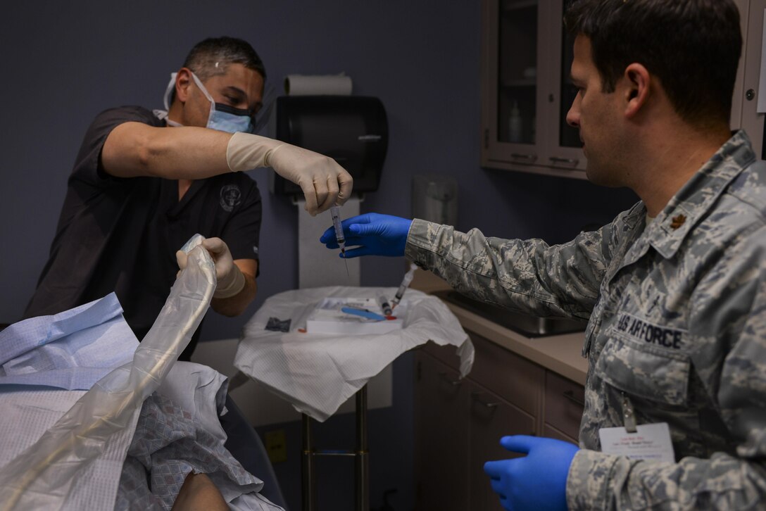 Maj. (Dr.) Joe Restivo, D.O., 99th Medical Support Squadron pathologist, and Lt. Col (Dr.) David Wang, D.O., 99th interventional radiologist, collaborate to perform a fine needle aspiration biopsy at the Mike O’Callaghan Federal Medical Center at Nellis Air Force Base, Nev., on April 15, 2016. The liquid specimen obtained is evaluated immediately at the bedside providing rapid diagnostic information. (U.S. Air Force photo by Airman 1st Class Nathan Byrnes)