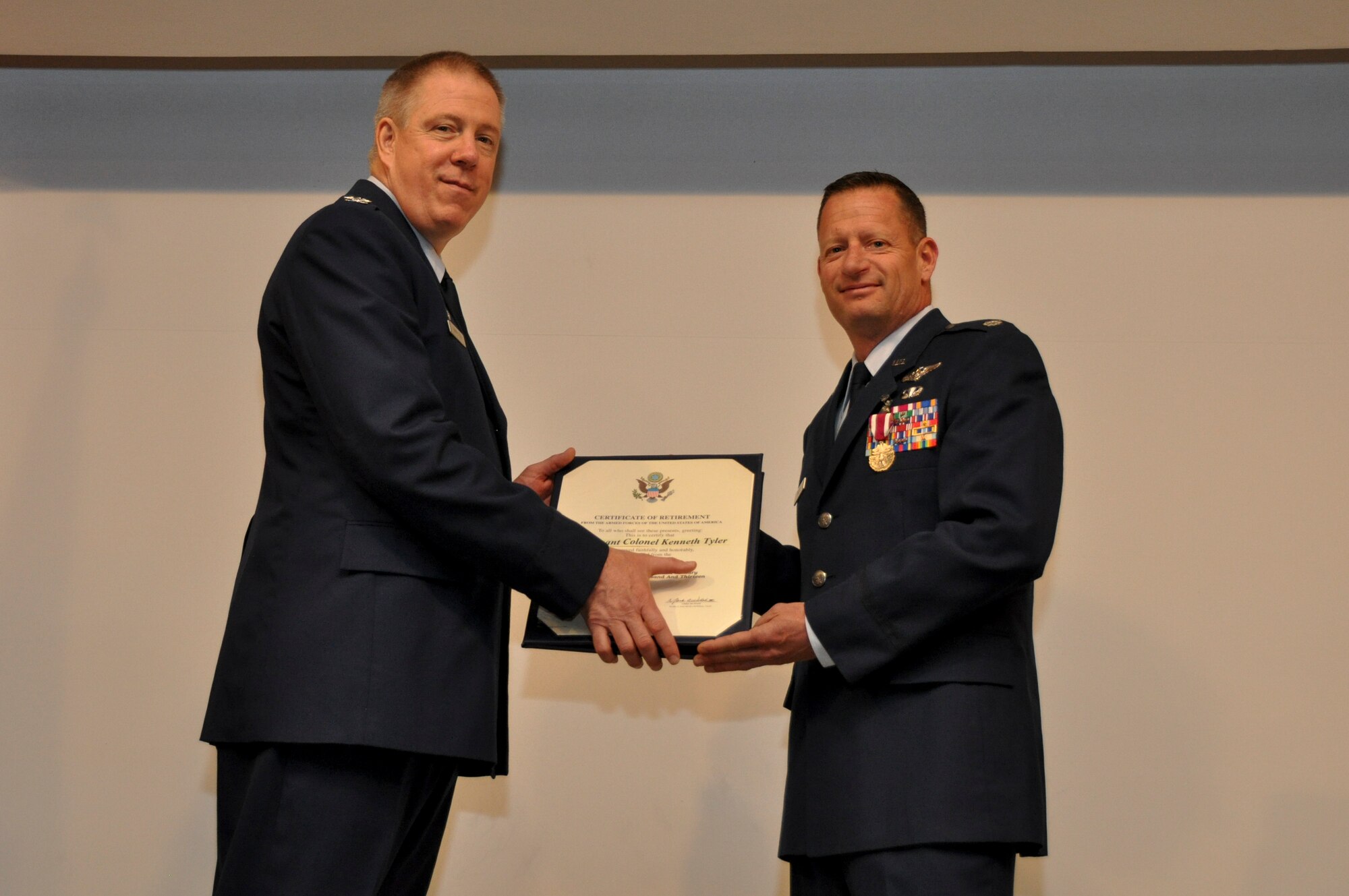 Col. Timothy Brininger, 349th Aeromedical Staging Squadron commander, presents Lt. Col. Kenneth Tyler with a certificate of retirement during a ceremony April 3, 2016, at Travis Air Force Base, Calif. Tyler, the 349th ASTS chief nurse, retired after more than 29 years of service. (U.S. Air Force photos/SrA Sajjan Singh)