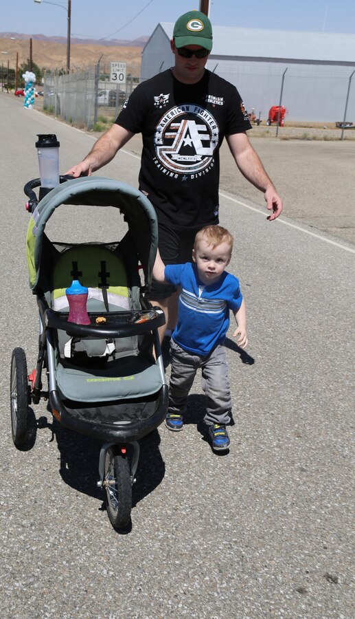 Sgt. Jeffery Avery, assistant inspector chief with the Inspector General's Office, and his 2-year-old son, Blake, stroll their way through the No More 5K aboard Marine Corps Logistics Base Barstow, Calif., April 15. The event brought awareness to domestic violence and sexual assault prevention. 