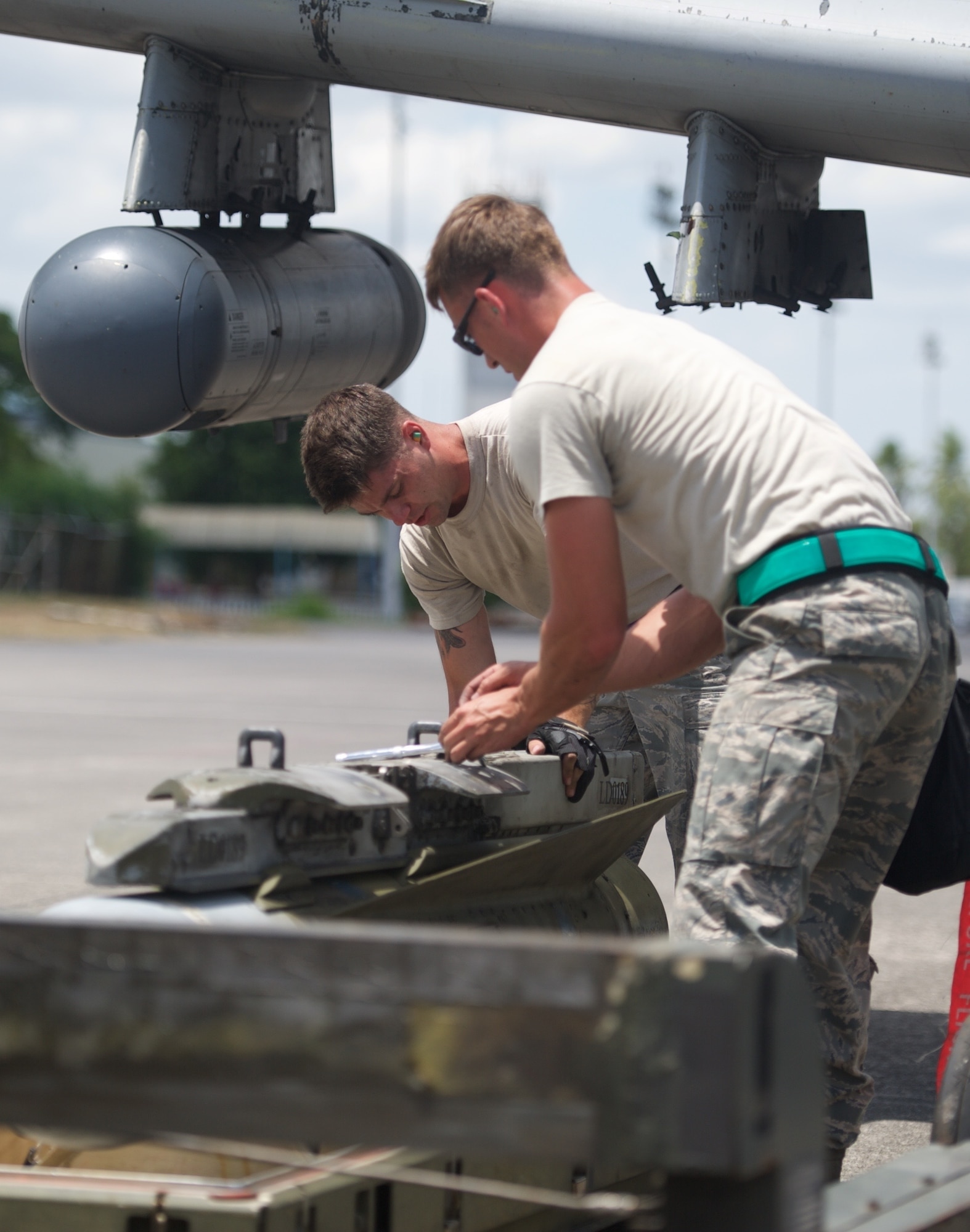 U.S. Air Force Staff Sgt. Kyle Whetham, weapons load crew chief, and Senior Airman Jonathan Simmons, weapons load crew member, inspect a training round from an A-10C Thunderbolt II after the aircraft completed a maritime domain awareness mission in the vicinity of Scarborough Shoal west of the Philippines April 21, 2016. These missions are intended to provide more transparent air and maritime situational awareness to ensure safety for military and civilian activities in international waters and airspace, and as such, the aircraft do not carry live rounds. Whetham and Simmons are deployed to Clark Air Base, Philippines from Osan Air Base, Republic of Korea. (U.S. Air Force photo by Capt. Susan Harrington)