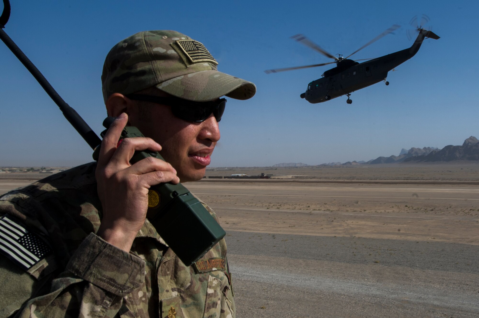 U.S. Air Force Maj. Brian Cruz, Regional Command South air mobility liaison officer, communicates with aircraft from the top of the control tower at Forward Operating Base Farah in Western Afghanistan, Oct. 19, 2013. AMLOs were called in to operate the landing zone and help close the FOB. They are the air mobility link between the AF and its sister services. (U.S. Air Force photo by  Staff Sgt. Stephany Richards