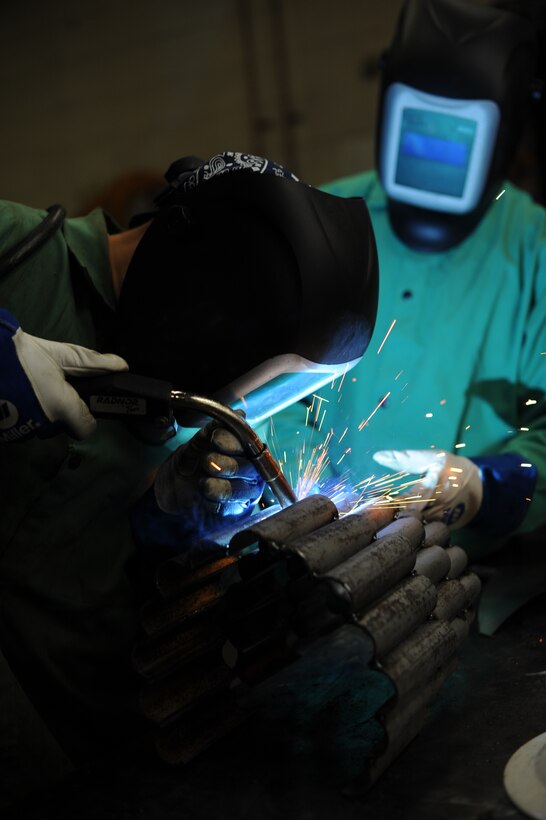 Staff Sgt. Corina Waxenfelter, 22nd Civil Engineer Squadron structures craftsman, welds the base of a sculpture during the 2016 Welding Competition, April 20, 2016, at McConnell Air Force Base, Kan. The event featured three different welding skill tasks and a creative construction portion with a 60th Anniversary KC-135 Stratotanker theme. (U.S. Air Force photo/Airman Jenna K. Caldwell)   