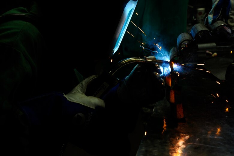 Staff Sgt. Corina Waxenfelter, 22nd Civil Engineer Squadron structures craftsman, welds the base of a sculpture during the 2016 Welding Competition, April 20, 2016, at McConnell Air Force Base, Kan. The event featured three different welding skill tasks and a creative construction portion with a 60th Anniversary KC-135 Stratotanker theme. (U.S. Air Force photo/Airman Jenna K. Caldwell)   