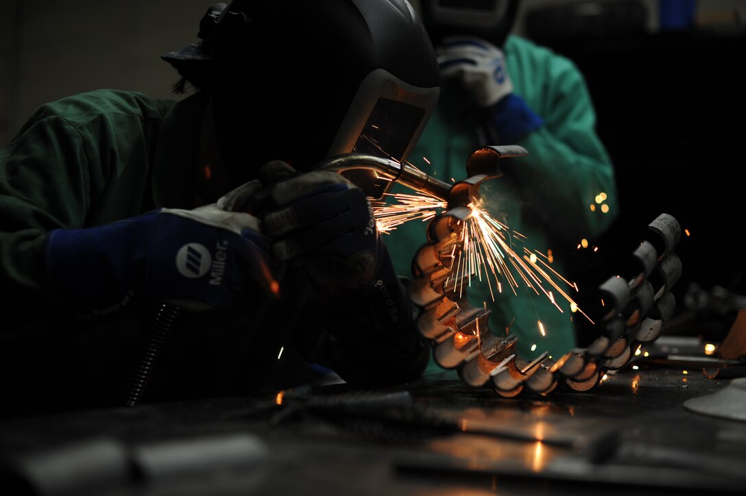 Staff Sgt. Corina Waxenfelter, 22nd Civil Engineer Squadron structures craftsman, welds the base of a sculpture during the 2016 Welding Competition, April 20, 2016, at McConnell Air Force Base, Kan. The event featured three different welding skill tasks and a creative construction portion with a 60th Anniversary KC-135 Stratotanker theme. (U.S. Air Force photo/Airman Jenna K. Caldwell)   