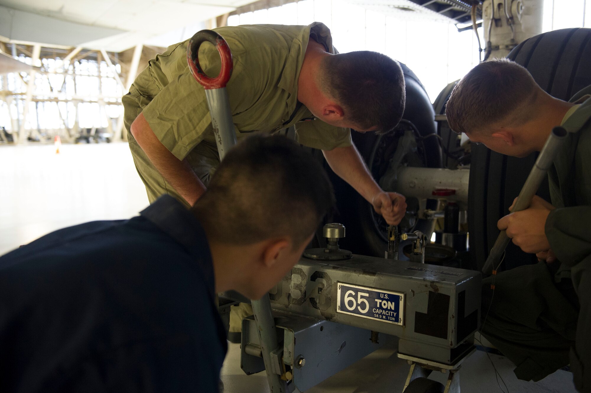 Staff Sgt. Wesley Cress, 92nd Maintenance Squadron isochronal floor supervisor, and his team position a tire jack during the bases first KC-135 Stratotanker tire changing competition April 22, 2016, at Fairchild Air Force Base, Wash. Approximately 20 Airmen, consisting of five teams and about seven different career fields, competed in the base’s first tire changing competition. (U.S. Air Force photo/Airman 1st Class Nick J. Daniello)