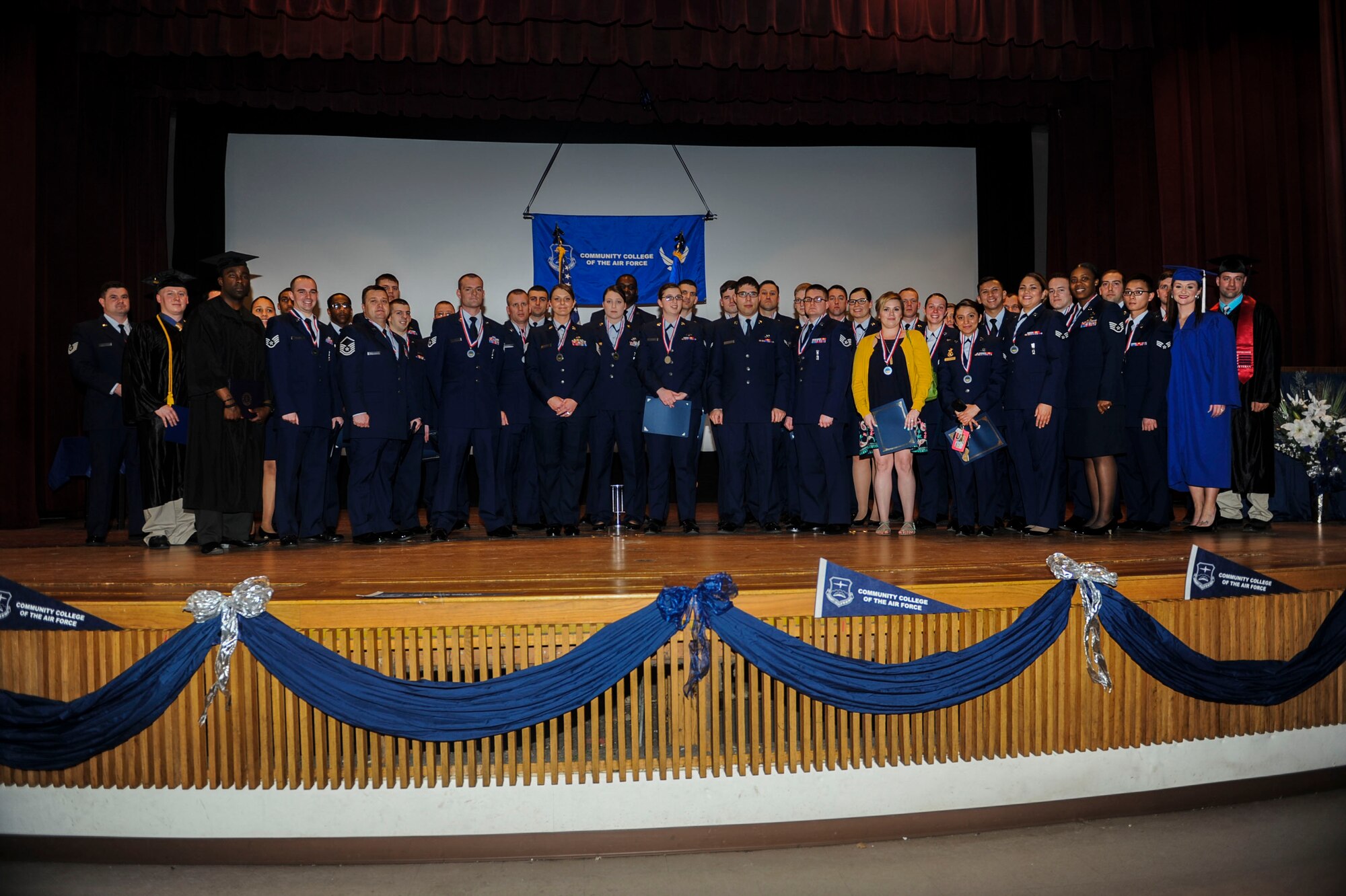 Airmen take an official photo as part of a combined graduation ceremony at Minot Air Force Base, N.D. base theater, April 21, 2016. Overall, 39 Airmen earned degrees from the Community College of the Air Force, three Airmen received Bachelors degrees and one Airman received a Masters degree. (U.S. Air Force Photo/Airman 1st Class Jessica Weissman)