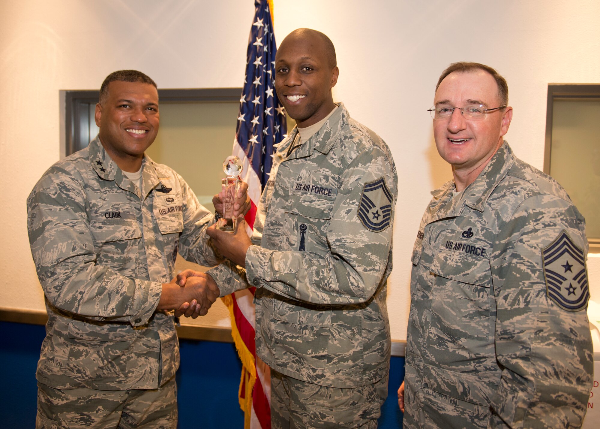 Maj. Gen. Richard Clark, 8th Air Force commander, presents Senior Master Sgt. Anthony Anderson, 705th Munitions Squadron flight chief, with the 2015 8th Air Force Senior NCO of the Year award at Minot Air Force Base, N.D., April 13, 2016. Clark and Chief Master Sgt. Marty Anderson, 8th Air Force command chief, visited Team Minot Airmen during Air Force Global Strike Command’s Exercise Constant Vigilance 2016. (U.S. Air Force photo/Airman 1st Class J.T. Armstrong)