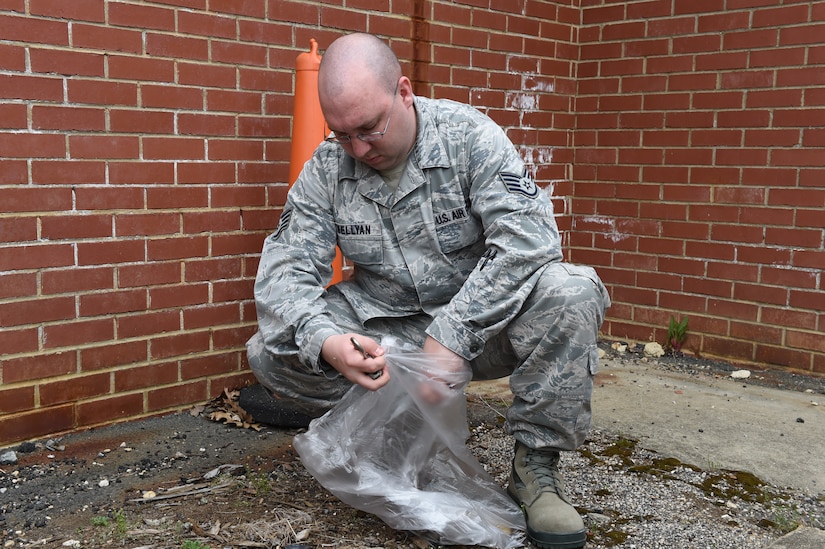Staff Sgt. John Lewellyan, 89th Aerial Port Squadron passenger service supervisor, picks up garbage around the flight line and passenger terminal at Joint Base Andrews, Md., April 22, 2016. Team Andrews cleaned up around base in commemoration of Earth Day. (U.S. Air Force photo by Senior Airman Joshua R. M. Dewberry/RELEASED)