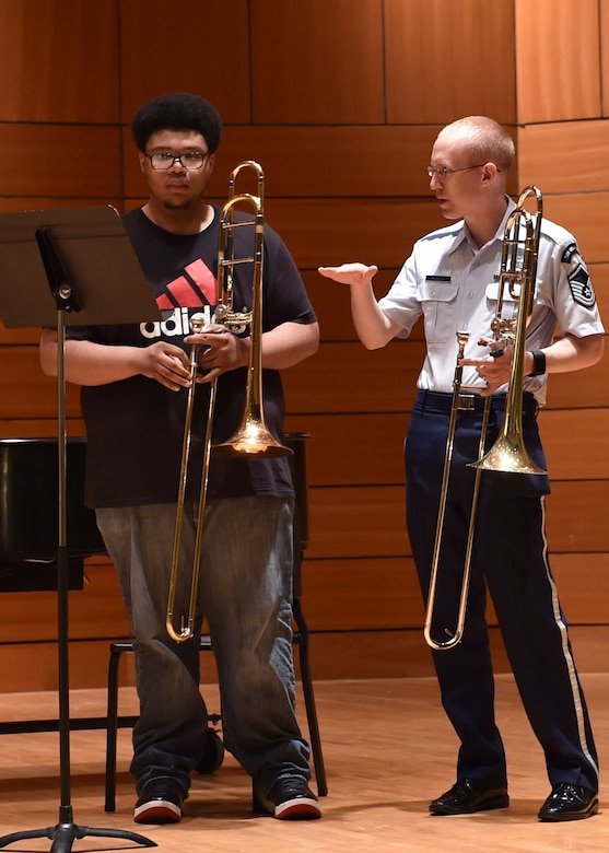 Master Sgt. Matthew Nudell, U.S. Air Force Concert Band trombonist, speaks to a music student during an Advancing Innovation through Music clinic at the University of Mississippi, Oxford, Ms., April 15, 2016. The band worked with roughly 1,000 students from 14 schools across five states on the tour as part of the AIM program. (U.S. Air Force photo by Senior Airman Dylan Nuckolls/Released)