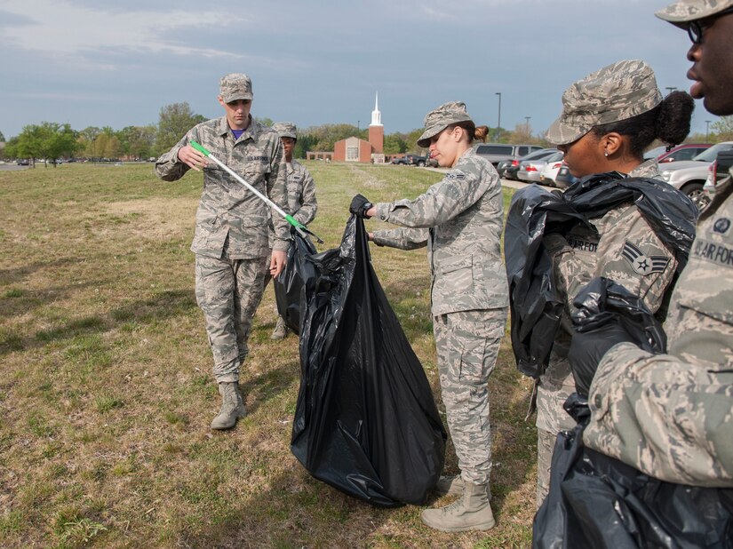 Airman 1st Class Darlena Vazques Quinones, 11th Comptroller Squadron military pay technician, assists Airman 1st Class Joseph Violette, 11th CPTS travel technician, with disposing trash at Joint Base Andrews, Md., April 22, 2016. The Airmen assisted with the base-wide clean up in commemoration of Earth Day. (U.S. Air Force photo by Airman Gabrielle Spalding/Released) 
