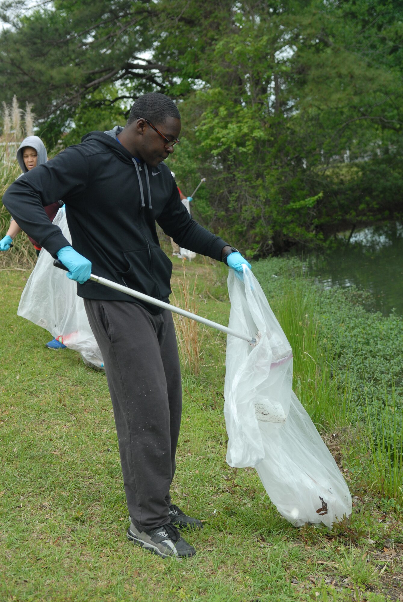 Airman 1st Class James Harris, 116th Aviation resource management, picks up trash during the Scout and Luna Lakes clean up day, April 15. (U.S. Air Force photo by Misuzu Allen)
