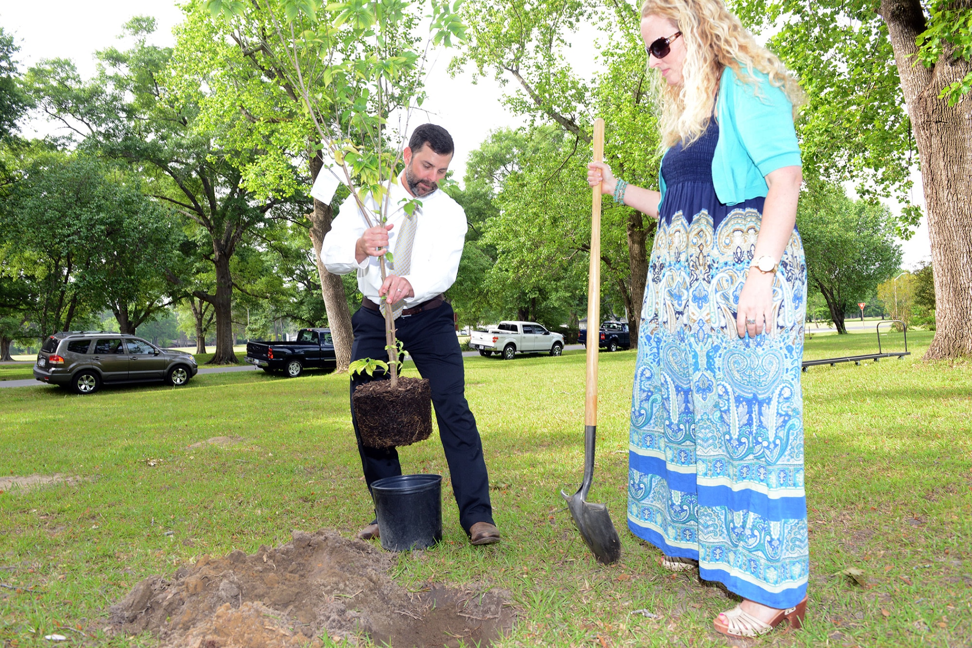 Jacob Tuttle 78th Civil Engineering Group natural and cultural resources program manager, helps Krista Mott, 78th Civil Engineering Group Geographic Information System specialist, plant the Flowering Dogwood dedicated in her honor Wednesday during the Arbor Day Ceremony. (U.S. Air Force photo by Tommie Horton)
