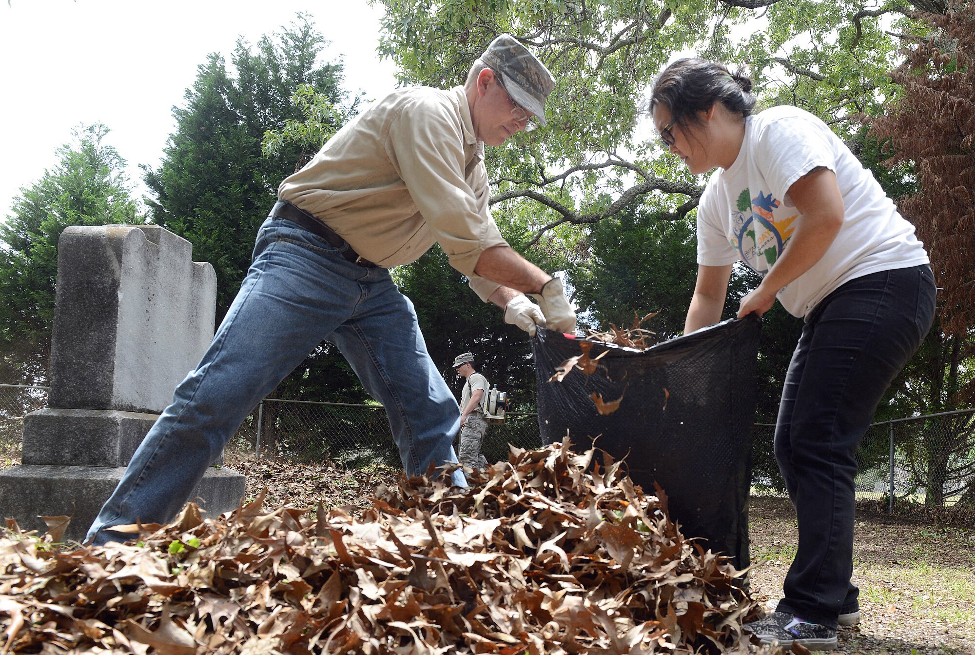 John Hyde, 78th Civil Engineering Group environmental community planner, and Esther Lee-Altman, Robins Installation Support Team, bag leaves as part of the Bryant Cemetery clean up, April 20, 2016 . (U.S. Air Force photo by Tommie Horton)
