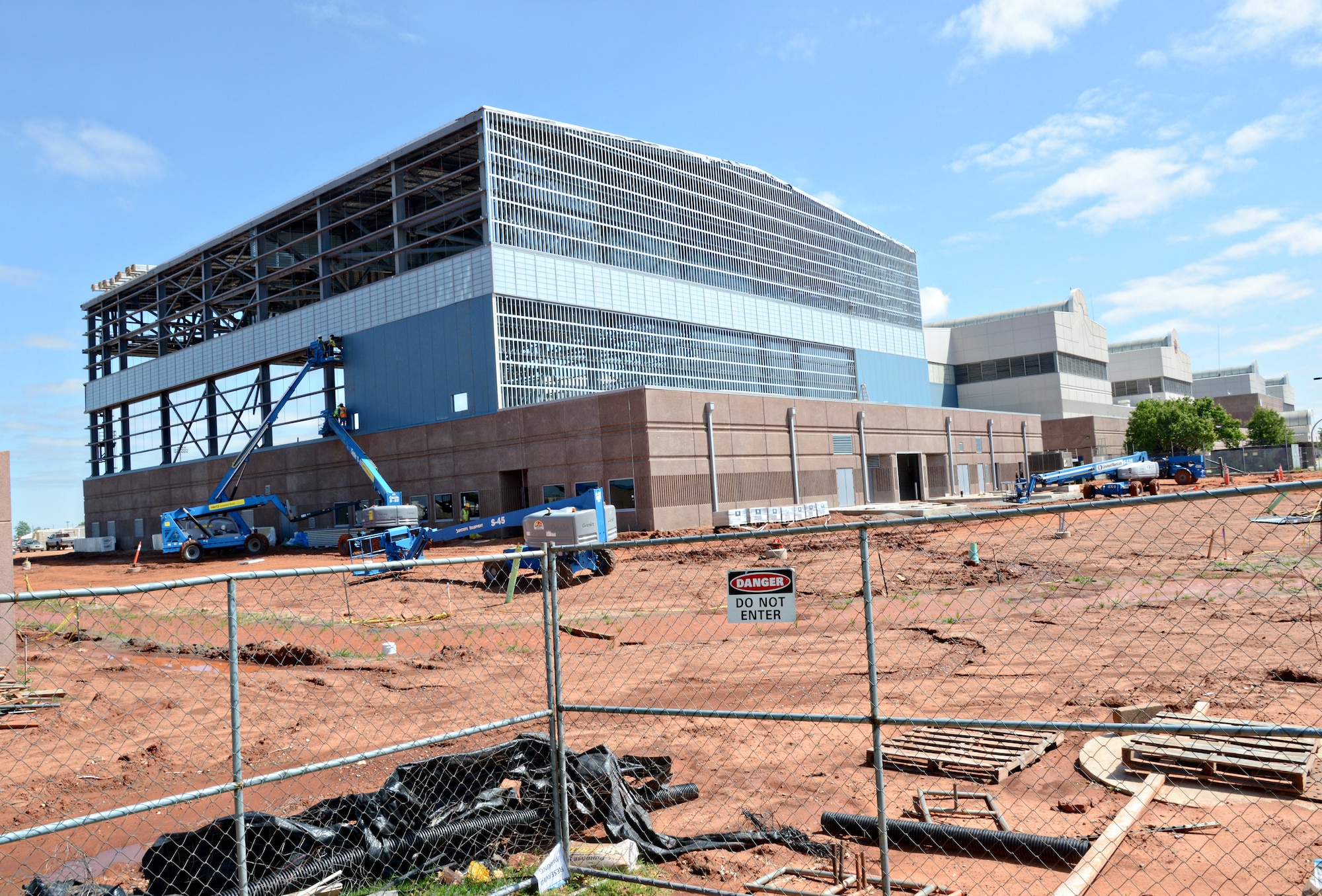 On the Navy side, a new aircraft hangar is being built. According to Scott Appleton, the onsite government construction manager with Naval Facilities and Engineering Command, the four original hangars were meant to be operational hangars, for things such as an oil change or quick turn maintenance items. The life of the E-6B has been significantly extended with the development of a programmed depot maintenance schedule.  The expertise of Navy engineers and Tinker artisans needed room to dedicate to PDM operations and execute their plan.  The Navy reviewed the requirements, and at a cost of roughly $18 million, the decision was made to build a new hangar.  It is estimated to be completed sometime in August. (Air Force photo by Kelly White/Released)