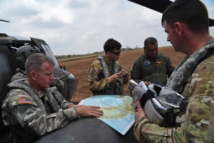 A UH-60 Black Hawk crew assigned to the 1st Battalion, 228th Aviation Regiment, a unit assigned to Joint Task Force Bravo at Soto Cano Air Base, Honduras, speaks to a member of the Panamanian Public Forces before fighting wildfires in the Darién province of Panama, April 18, 2016. The real-world operation provided an opportunity for U.S. and Panamanian forces to work closely together outside of a training environment, such as CENTAM SMOKE, or Sharing Mutual Operational Knowledge and Experiences, a semi-annual firefighting exercise hosted at Soto Cano AB. (U.S. Air Force photo by Staff Sgt. Siuta B. Ika)