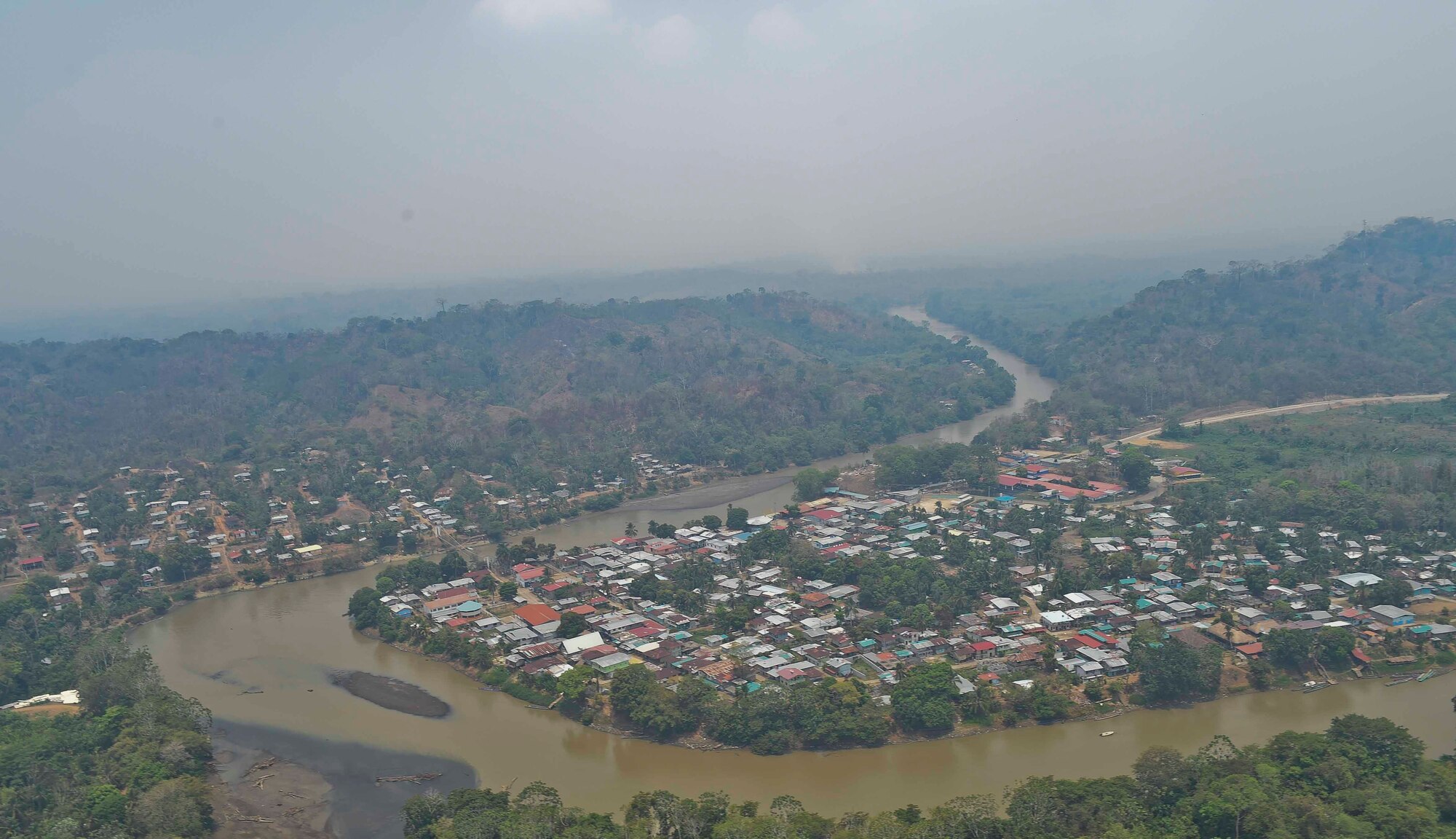 A town in the Darién province of Panama is seen overhead from a Joint Task Force-Bravo helicopter, with smoke from a wildfire surrounding it, April 18, 2016. Members of JTF-Bravo partnered with Panamanian Public Forces to contain multiple life-threatening wildfires in the region. Approximately 45,000 people reside in the Darién Province so stopping the spread of the fire from the undeveloped swampland and forests to residential areas was of utmost importance. (U.S. Air Force photo by Staff Sgt. Siuta B. Ika)