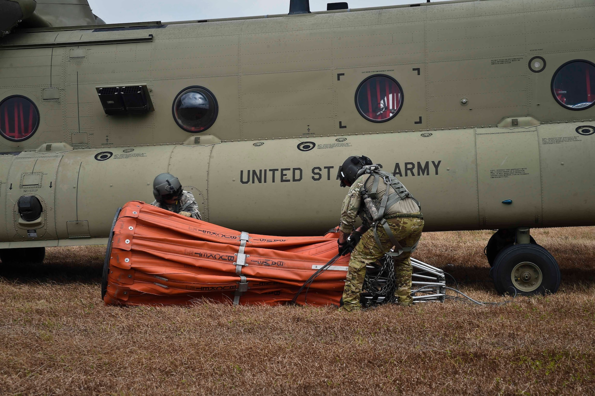U.S. Army Staff Sgt. John Fajota and Sgt. 1st Class Christopher Gagnon, both CH-47 Chinook crew members assigned to the 1st Battalion, 228th Aviation Regiment, prepare to connect a Bambi Bucket to a Chinook for a firefighting operation in the Darién province of Panama, April 18, 2016. The air assets of the 1-228th AVN dropped approximately 100,000 gallons of water during the firefighting operation. (U.S. Air Force photo by Staff Sgt. Siuta B. Ika)