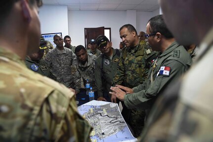 Members of the Panamanian Public Forces and the 1st Battalion, 228th Aviation Regiment, a unit assigned to Joint Task Force Bravo, Soto Cano Air Base, Honduras, discuss operational details before fighting wildfires in the Darién province of Panama, April 17, 2016. During the operation, Panamanian and U.S. command and control elements reviewed inputs from the ground forces and surveillance from air assets to determine where the fire, which had split into hundreds of separate fires, needed the most attention. (U.S. Air Force photo by Staff Sgt. Siuta B. Ika)